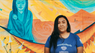 New Mexico mother stands in front of a mural