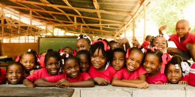 Building community - School children in Haiti dressed in red uniforms.
