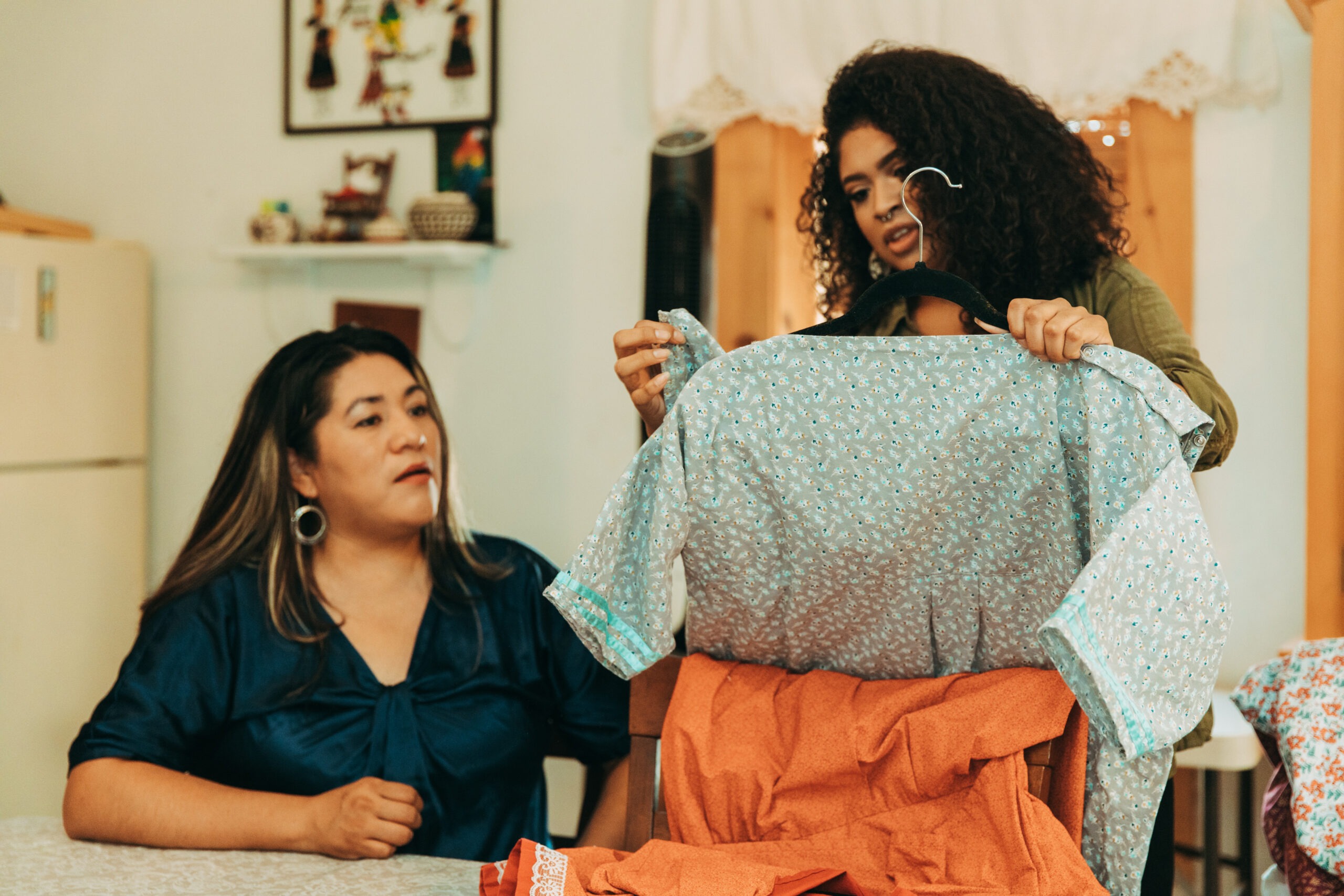 Malia Luarkie showing off a dress to another breastfeeding mother.