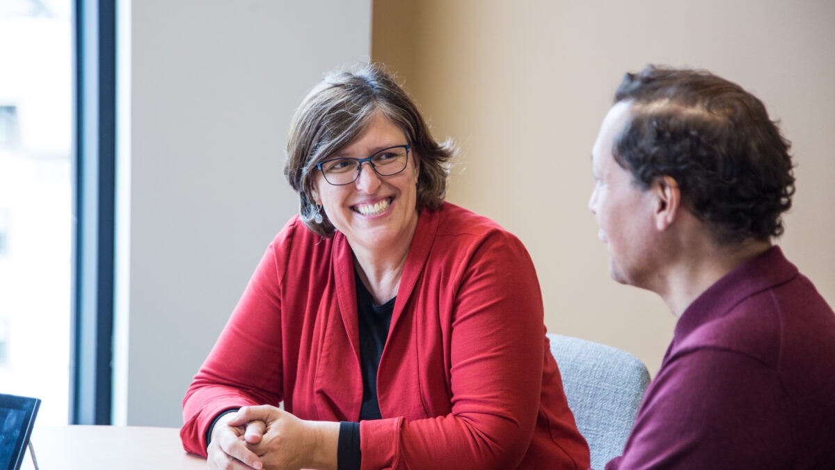 Christina Jennings and John Ramirez of Latino Economic Development Center sits at a table for a meeting at Impact Hub MSP office located in downtown Minneapolis.