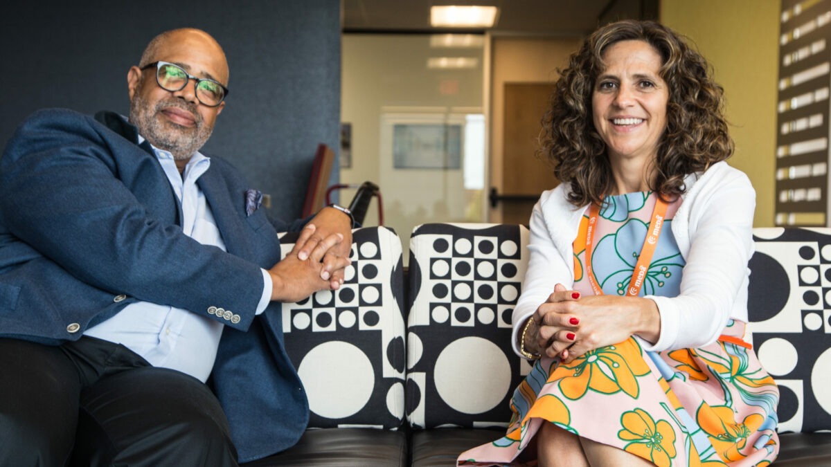 Gary Cunninggam and Joanna Ramirez Barrett sitting on a couch at the Meda office.