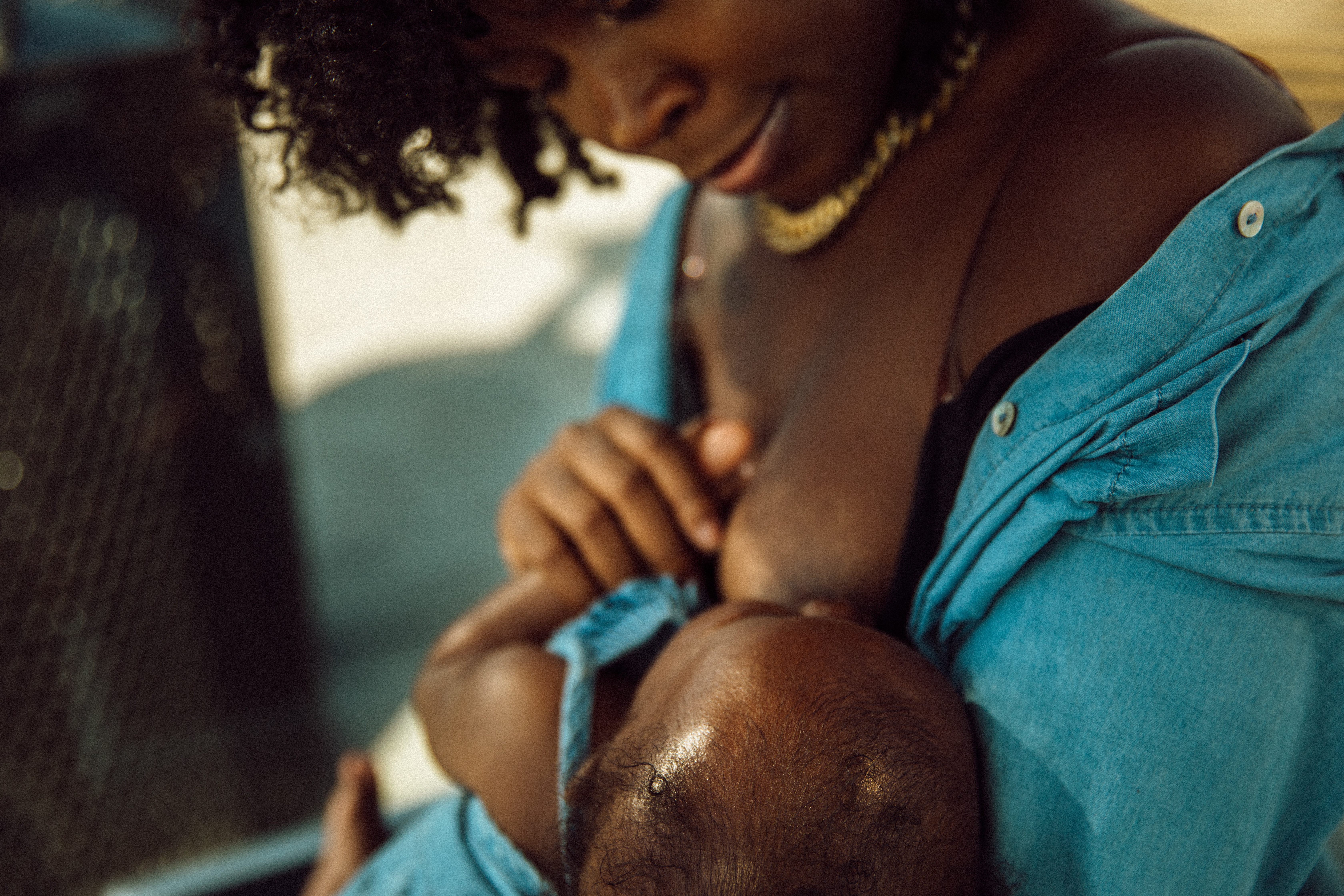 Janel Vee breastfeeds her infant daughter outside at a bus stop.