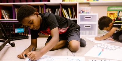 Young boys of color drawing in a classroom