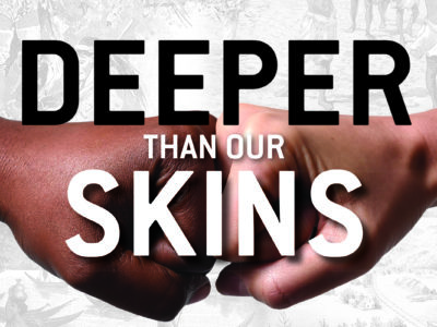 A fist pump between two different colored individuals with the words "Deeper than our skins" overlay on the image.
