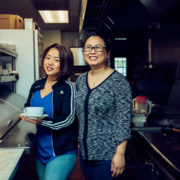 Amanda Sunthang and her mom, owners of Shwe Mandalay Burmese Cuisine restaurant located in Battle Creek, Michigan, standing in the kitchen.