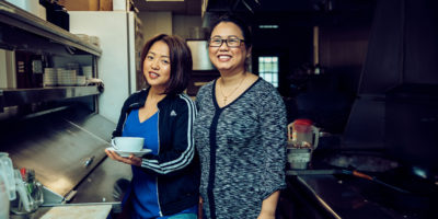 Amanda Sunthang and her mom, owners of Shwe Mandalay Burmese Cuisine restaurant located in Battle Creek, Michigan, standing in the kitchen.