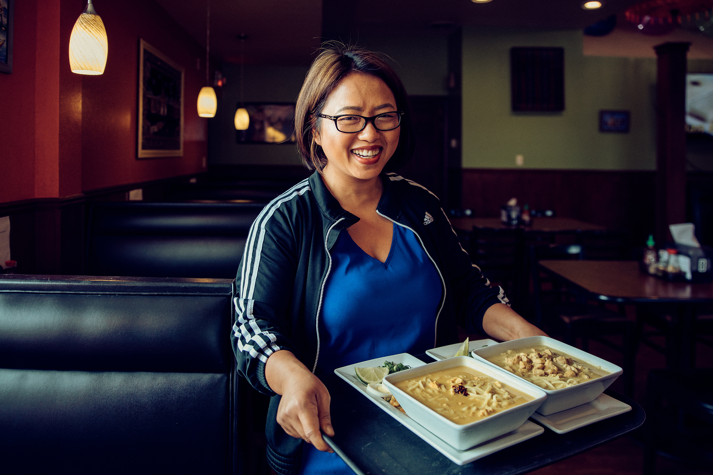 Amanda Sunthang carrying a tray of food inside the Shwe Mandalay Burmese Cuisine restaurant in Battle Creek, Michigan.