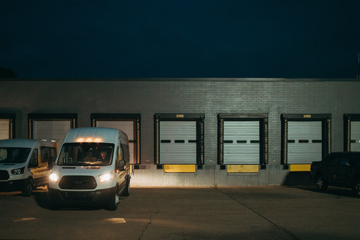 Aequitas van with its headlights on parked in a loading dock area in Battle Creek, MI. Aequitas removes transit barriers for employment opportunities.