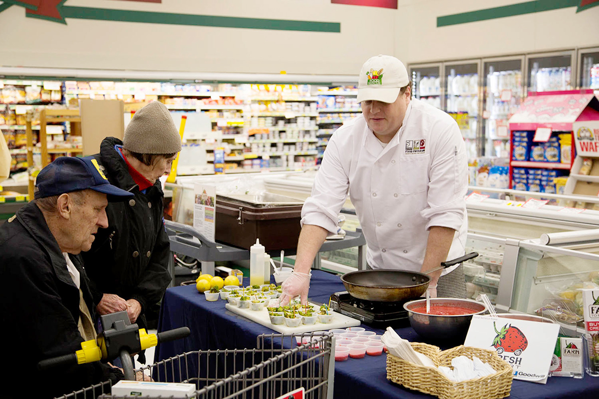 Goodwill's "Chef" Ben serves up tastings at the local grocer using Goodwill's Farm to Freezer products. Photo: Farm to Freezer.