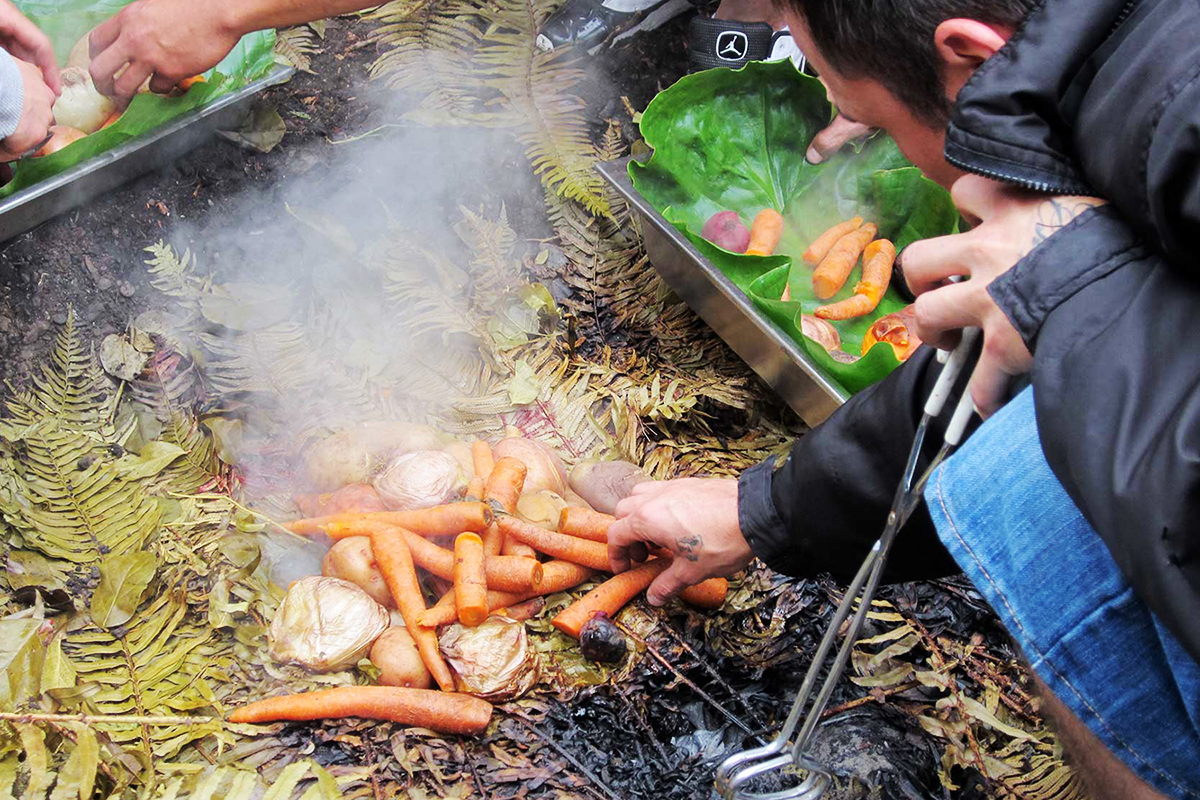Root vegetables, including carrots and potatoes, are roasted over a traditional “oven” in the same way tribal ancestors would have done. Photo: Valerie Segrest.