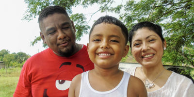 A Mexican family of three smiling.