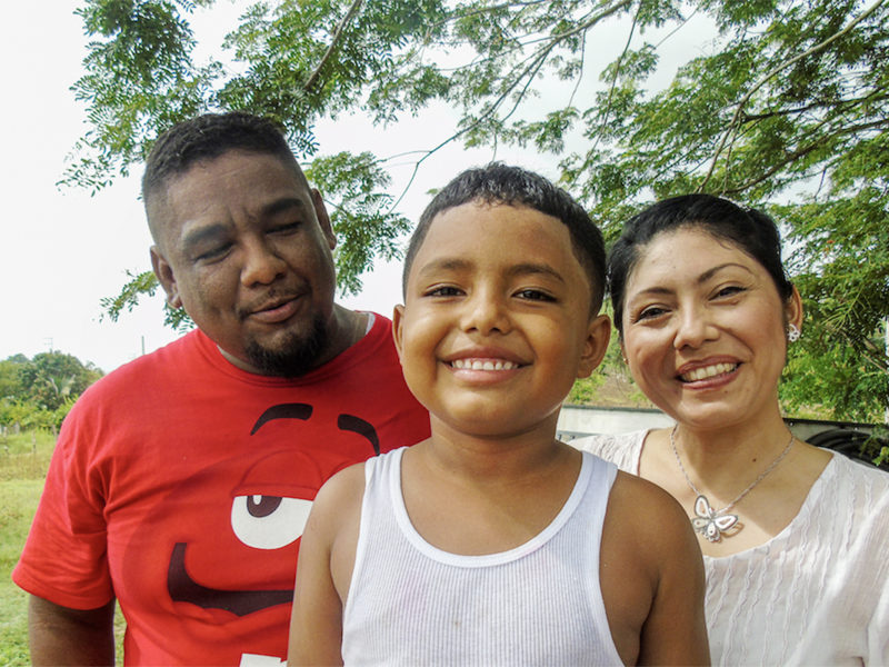 A Mexican family of three smiling.