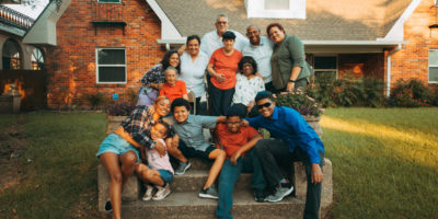 A family of 13 people on the front steps of their house in New Orleans.