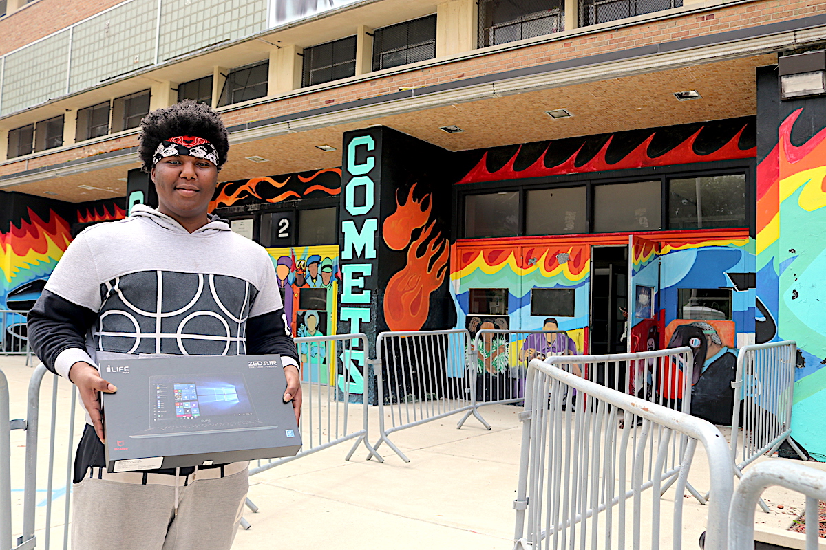 Child standing outside of retail shop in Detroit. Bridging the digital divide in Detroit