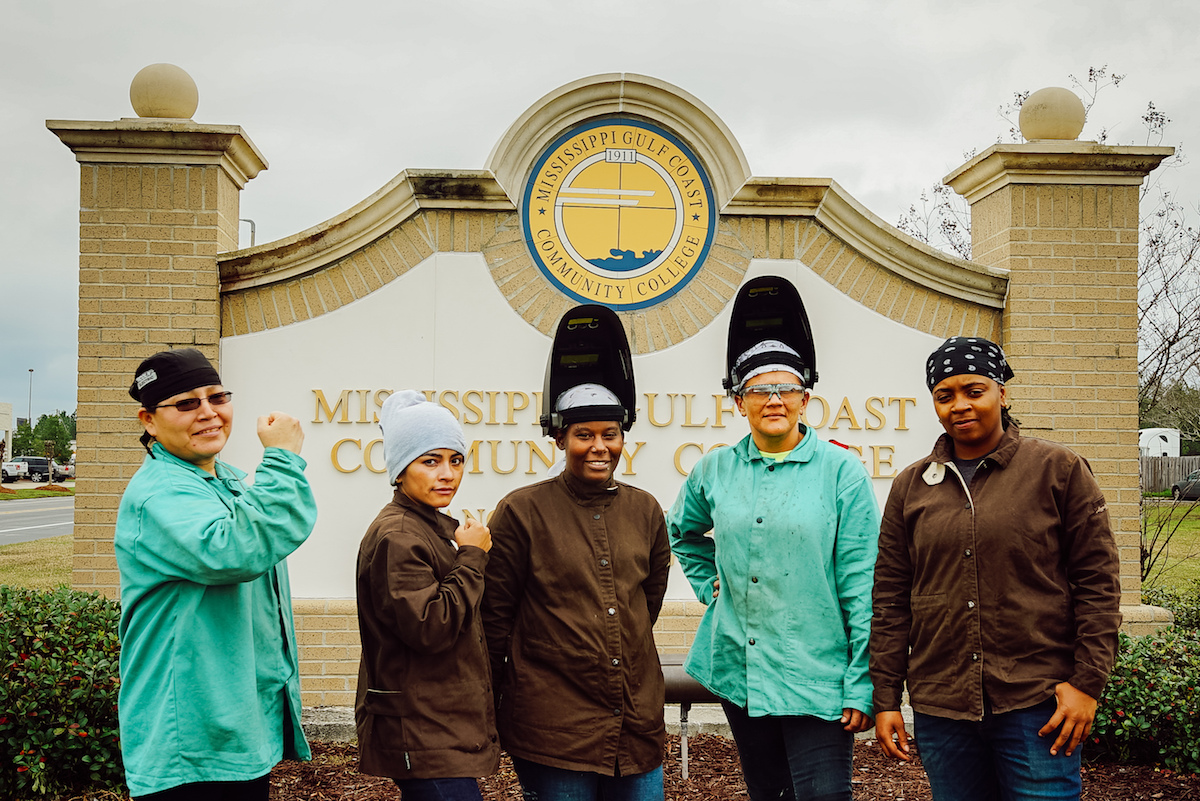 mississippi residents posing for a picture in front of the town sign. WKKF is establishing different methods for different communities