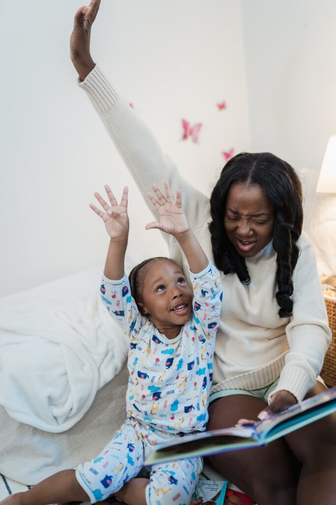 A Black parent and child celebrate "reach for the stars" while reading.