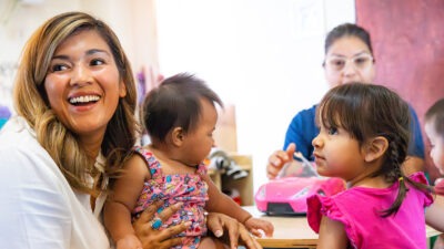 Children and caregivers sitting at table | W.K. Kellogg Foundation