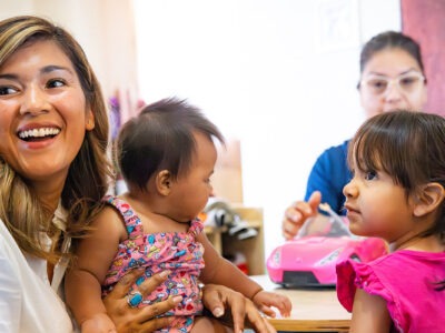 Children and caregivers sitting at table | W.K. Kellogg Foundation