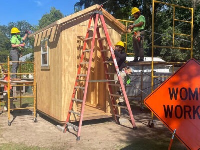 Women construction workers building a shed