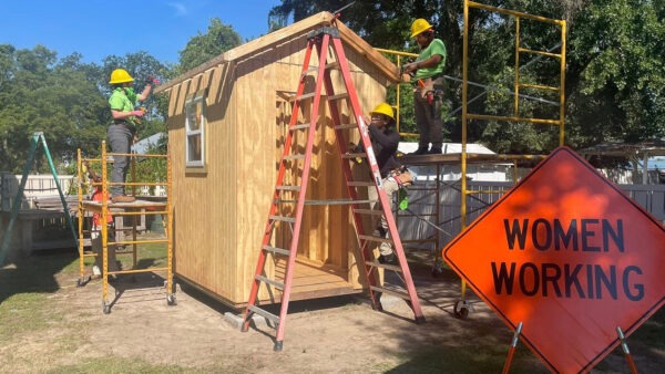 Women construction workers building a shed