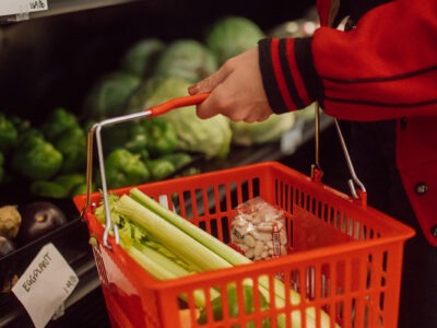 person holding a shopping basket filled with vegetables | W.K. Kellogg Foundation
