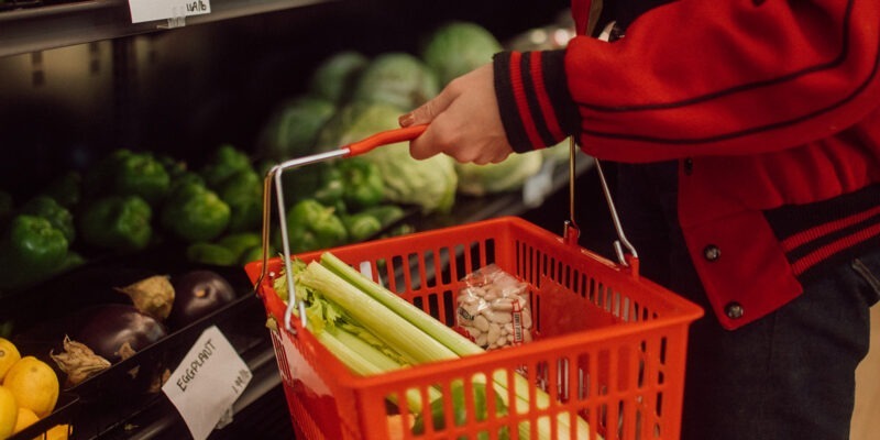 person holding a shopping basket filled with vegetables | W.K. Kellogg Foundation