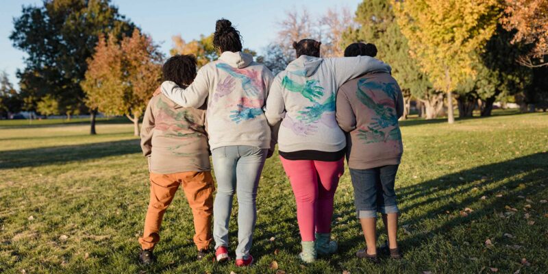 Black Leader's Circle Women in sweatshirts with hug prints on the back