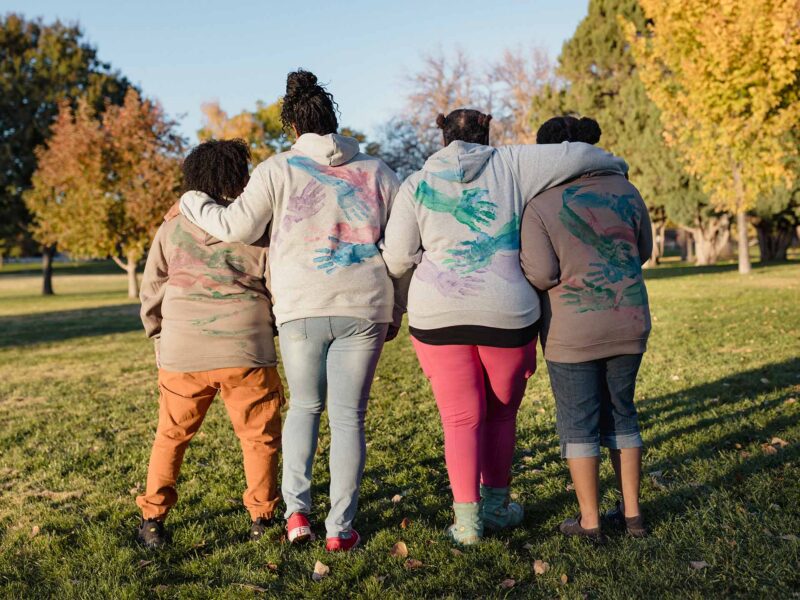 Black Leader's Circle Women in sweatshirts with hug prints on the back