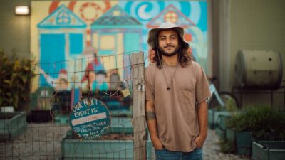 Alec Devaprasad stands at Sprout's community garden, where he went from tending his first garden bed to becoming an independent farmer.