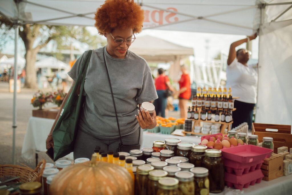 A customer explores locally made preserves at the Crescent City Farmers Market, where families can buy fresh produce, including with SNAP benefits, directly from Sprout-supported growers.