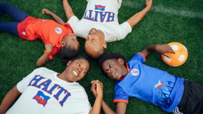 Family laying on lawn with soccer ball